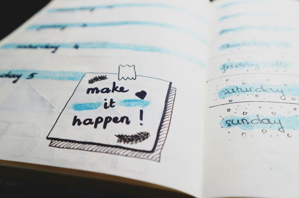 a drawing of a post-it note in a planner states "Make it happen"